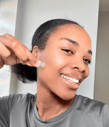 Smiling woman applying Spot Saviour acne patch – real user applying touch-free pimple treatment